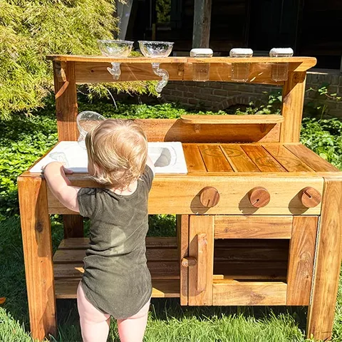 A toddler at the outdoor mud kitchen
